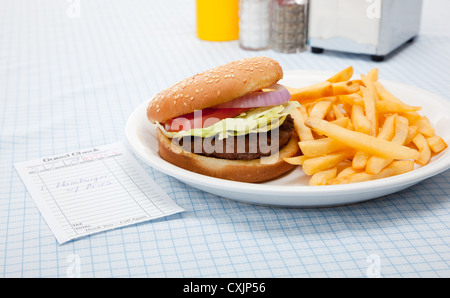 Mahlzeit des Hamburger und Pommes Frites mit einer Guest-Check auf einer blau karierte Tischdecke Stockfoto
