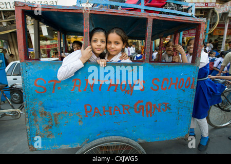 Schülerinnen und Schüler in eine Fahrradrikscha "Schulbus" für St Anthony School auf Chandni Chowk, Alt-Delhi, Indien Stockfoto