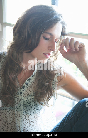 Close-up Portrait der Frau sitzt vor Fenster Stockfoto