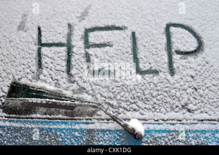 Hilfe-Wort geschrieben am hinteren Autofenster fallenden Schneefall Stockfoto