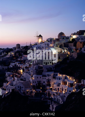 Weiße Straßen und Windmühlen von Oia bei Sonnenuntergang Stockfoto
