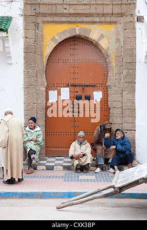 Marokkanische Männer im Kaftan sitzen Tür Essaouira, Marokko Stockfoto