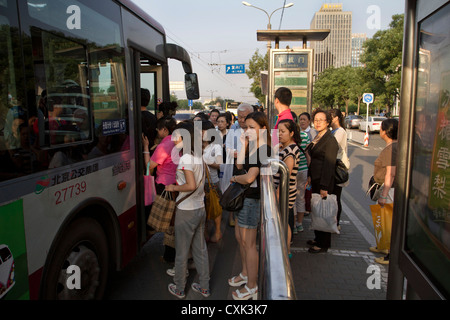 Passagiere warten auf einen Bus während der Hauptverkehrszeit am Fuchengmen im Zentrum von Peking, China zu begeben. Stockfoto