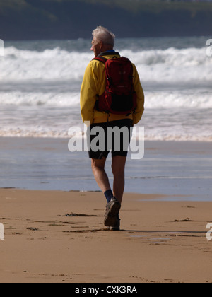 Alter Mann am Strand entlang, Cornwall, UK Stockfoto