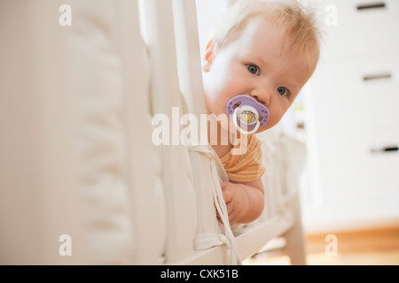 Porträt von Baby Mädchen auf der Suche von Krippe Stockfoto