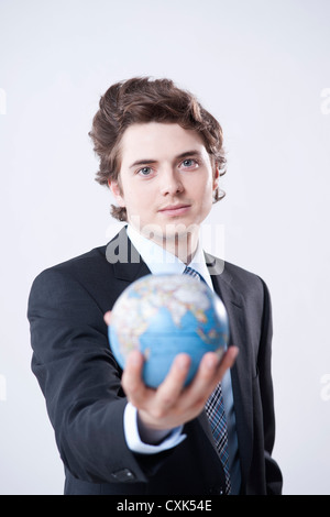 Porträt des jungen Geschäftsmann Globus holding Stockfoto