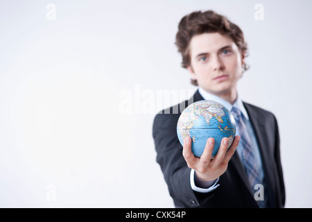 Porträt des jungen Geschäftsmann Globus holding Stockfoto