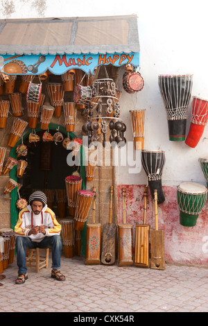 Mann verkauft Musikinstrumente außerhalb traditionelle Trommel shop Essaouira, Marokko Stockfoto