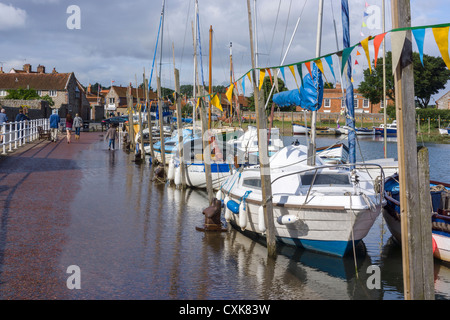 Boote vertäut im Hafen von Blakeney bei Flut mit dem Meer, auf dem Bürgersteig einzugreifen. Stockfoto