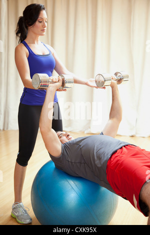 Ein Mann arbeitet mit einem weiblichen personal Trainer. Stockfoto