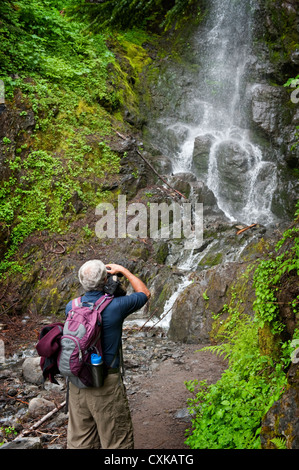 Ein Wanderer in der Mt. Baker National Forest stoppt, um ein Foto von einem wunderschönen Wasserfall entlang des Weges zu machen. Stockfoto