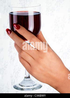 WEIBLICHE HAND HOLDING GLAS ROTWEIN Stockfoto