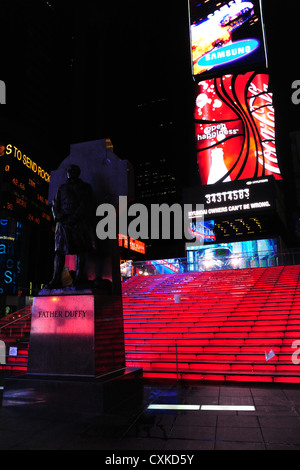 Am frühen Morgen Nacht Neon Porträt Vater Patrick Duffy Statue stehen rote TKTS Eingangstreppe, Times Square, 7th Avenue, New York Stockfoto