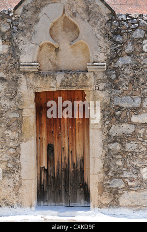 Griechischen Holztür mit interessanten Mauerwerk umgeben in der Hill Top Dorf von Kroustas, in der Nähe von Agios Nikolaos, Kreta, Griechenland Stockfoto