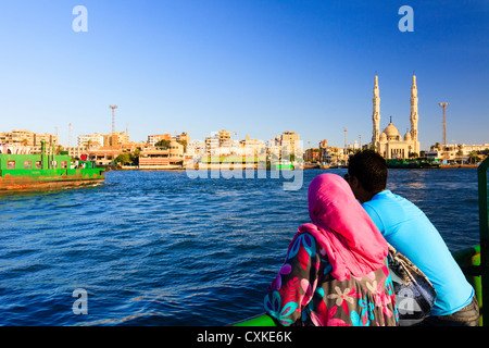 Ägyptischen paar auf der kostenlosen Fähre über den Suez-Kanal von Port Said, Port Fuad mit großen Moschee im Hintergrund. Ägypten Stockfoto