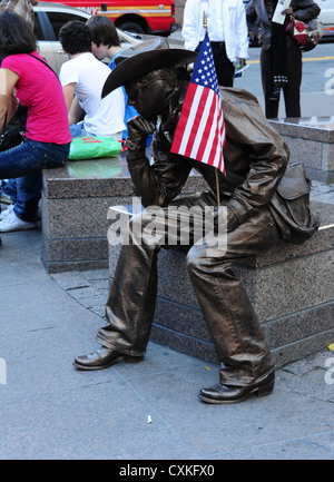 Maskierter Cowboy Pantomime, amerikanische Flagge, sitzend Granit Sitz, Zuccotti Park, Trinity Place at Liberty Street, New York Stockfoto