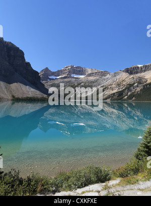 Berge spiegeln sich in den klaren, blauen Wasser des Bow Lake auf dem Icefields Parkway in Banff Nationalpark, Alberta, Kanada Stockfoto