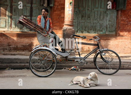 Dreirad-Rikscha-Fahrer mit Hund bei Sonnenuntergang. Varanasi. Indien Stockfoto