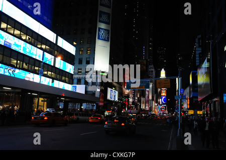 Nacht Neon Blick Richtung Times Square, rote Lichter Verkehr, blauen Fassade Barclays Bank, 7th Avenue in West 49th Street, New York Stockfoto