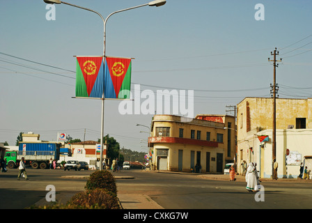 Eritrea, Asmara, zwei Frauen, die über eine leere Straße Gebäude im Hintergrund Stockfoto