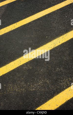 Schwarze Asphaltdecke gemalt mit gelben Streifen in einer diagonalen Linien mit Textfreiraum Stockfoto