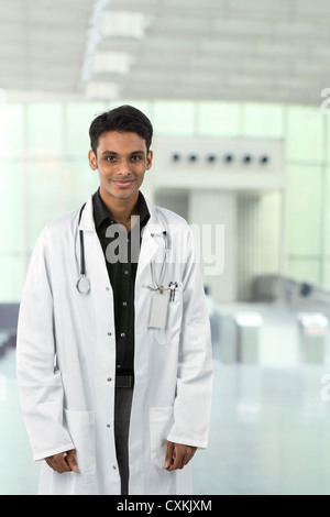 Junge männliche indische Arzt trägt einen weißen Kittel und Stethoskop. Stockfoto