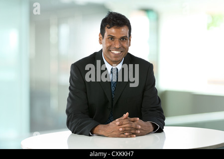 Porträt von einem indischen Geschäftsmann an einem Tisch sitzen. Stockfoto
