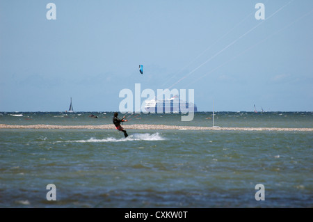 Kite-Surfer im Ozean mit Kreuzfahrtschiff auf Hintergrund Stockfoto