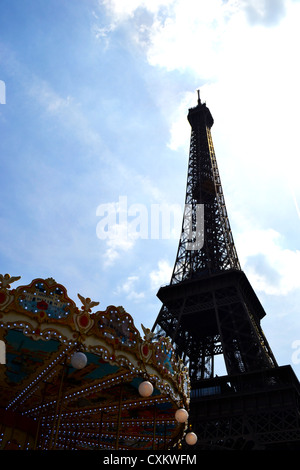 Der Eiffelturm, Paris, von unten gesehen an einem Sommertag mit einem Karussell im Vordergrund. Stockfoto