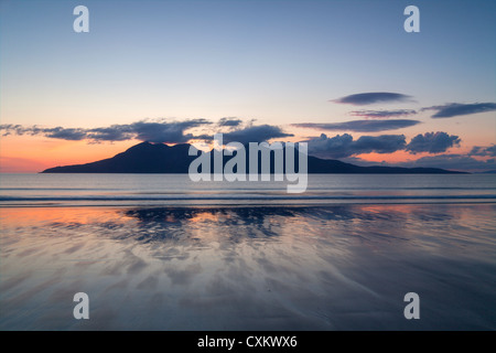 Reflexionen im nassen Sand auf die Bucht von Laig Insel Eigg Blick auf einen Sonnenuntergang über Rum. Stockfoto