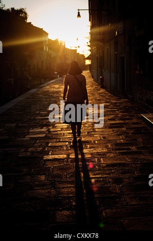 Eine Frau mit einem Hut zu Fuß in die Cannargeio während der Zeit des Sonnenuntergangs, Venedig, Italien. Stockfoto