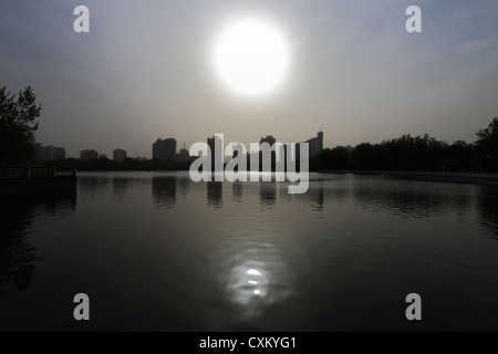 Blick auf den See und die Gebäude Skyline betonen den Smog, Lianhuachi Park, Beijing City, Provence, Peking, Asien. Stockfoto