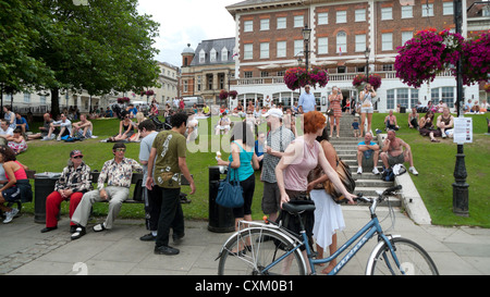 Menschen, die sich auf Bänken, Sitzterrassen und Fahrradfahrerin mit Fahrrad im Sommer entspannen Richmond upon Thames, London, England Großbritannien KATHY DEWITT Stockfoto