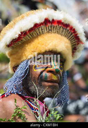 Porträt eines Mannes mit seinem Gesicht gemalt und tragen traditionelle Kopfbedeckung bei Singsing Goroka Festival, Papua New Guinea Stockfoto
