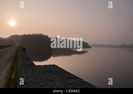 Schöne misty Abend Licht bei Sonnenuntergang über dem ruhigen Wasser des ländlichen, ruhigen malerischen See und Staumauer - Thruscross Reservoir, North Yorkshire, England, UK. Stockfoto