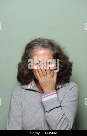 Porträt der schüchterne Frau mit Händen bedeckte Gesicht Stockfoto