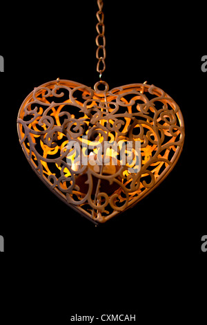 Ein Votiv Kerzenständer in Form eines Herzens an einer Kette hängend Stockfoto