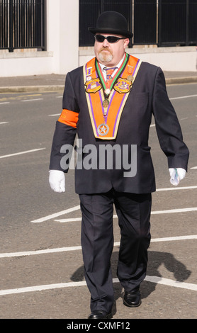 Bezirk Marschall Orangeman tragen traditionelle "Orange Flügel" und Melone marschieren auf einer Straße während einer Parade der Oranier-Orden Stockfoto