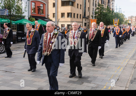 Anzahl der Oranier traditionelle Orange-Schärpe zu tragen, wie sie auf einer Straße während einer Parade der Oranier-Orden marschieren Stockfoto