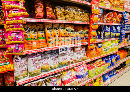 Pakete der Marken Snacks und Chips für den Verkauf auf den Regalen in einen Poundland Shop Shop. Stockfoto