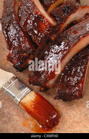 Leckeres BBQ Baby zurück ribs mit würziger Sauce und Sauce Bürste Stockfoto