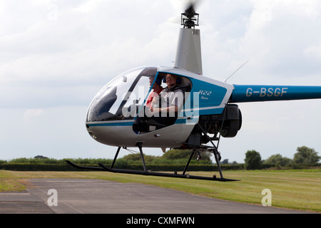 Robinson R22 Beta G-BSGF schwebt aver Rollweg Stockfoto