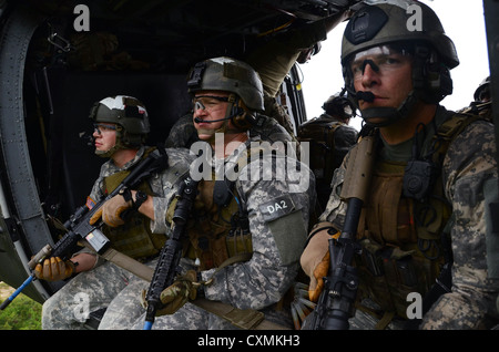 U.S. Army Special Forces Suche nach Bedrohungen während der Fahrt in einem MH-60 Black Hawk nach schnellen Abseilen auf ein Ziel während des Trainings August 2012 an der John F. Kennedy Special Warfare Center and School in Fort Bragg, North Carolina. Stockfoto