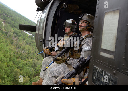 U.S. Army Special Forces Suche nach Bedrohungen während der Fahrt in einem MH-60 Black Hawk nach schnellen Abseilen auf ein Ziel während des Trainings August 2012 an der John F. Kennedy Special Warfare Center and School in Fort Bragg, North Carolina. Stockfoto