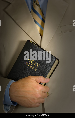 Mann hält eine Bibel, ein Business-Anzug mit einer Krawatte bekleidet Stockfoto