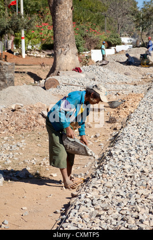 Myanmar, Burma, Shan-Staat. Arbeiter bauen eine asphaltierte Straße von Hand. Verlegung der Straße Bett aus Schotter. Stockfoto