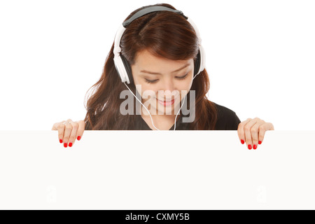 Eine junge Frau trägt einen Kopfhörer blickte auf eine Leerstelle Stockfoto