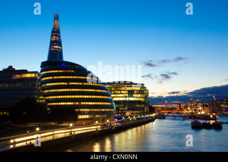 Blick von Westen von der Tower Bridge über Rathaus in die Ferne auf der Themse bei Nacht, London, England, UK Stockfoto