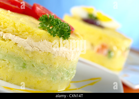 Peruanische Gericht namens Causa, die gelbe Kartoffelpüree gemacht, und hier, gefüllt mit Avocado und Hühnchen Stockfoto