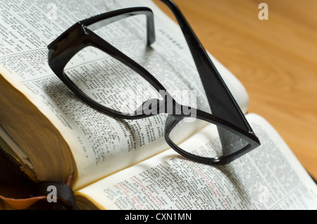 Ein paar Damen Lesebrille oben auf eine Bibel, religiösen Studien Stockfoto